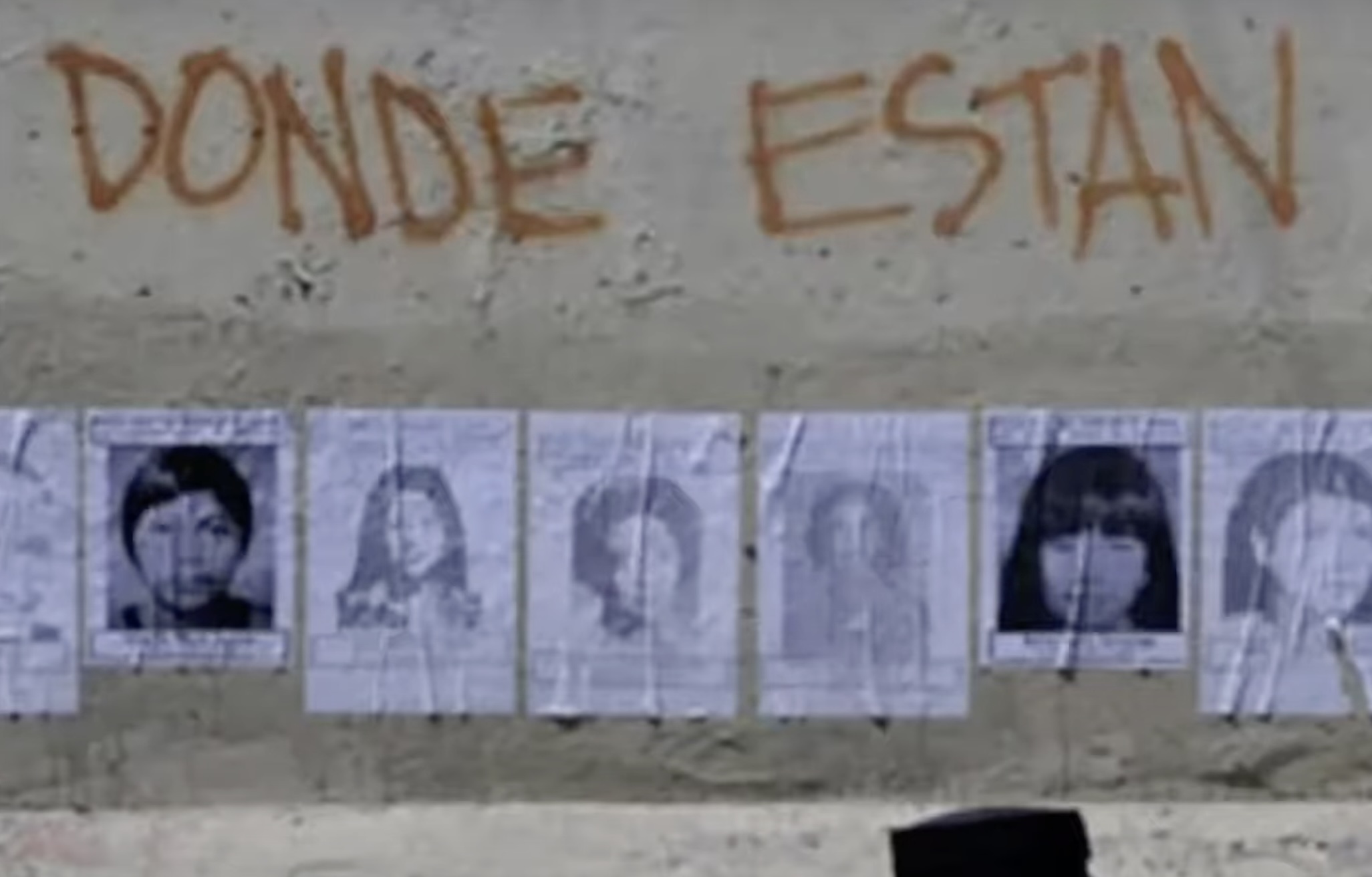 Wall in Terceravia, Mexico, with graffiti words, "Donde Estan." Photos of women's faces underneath.