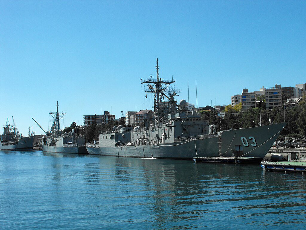 Photo of two large Adelaides frigates at dock.