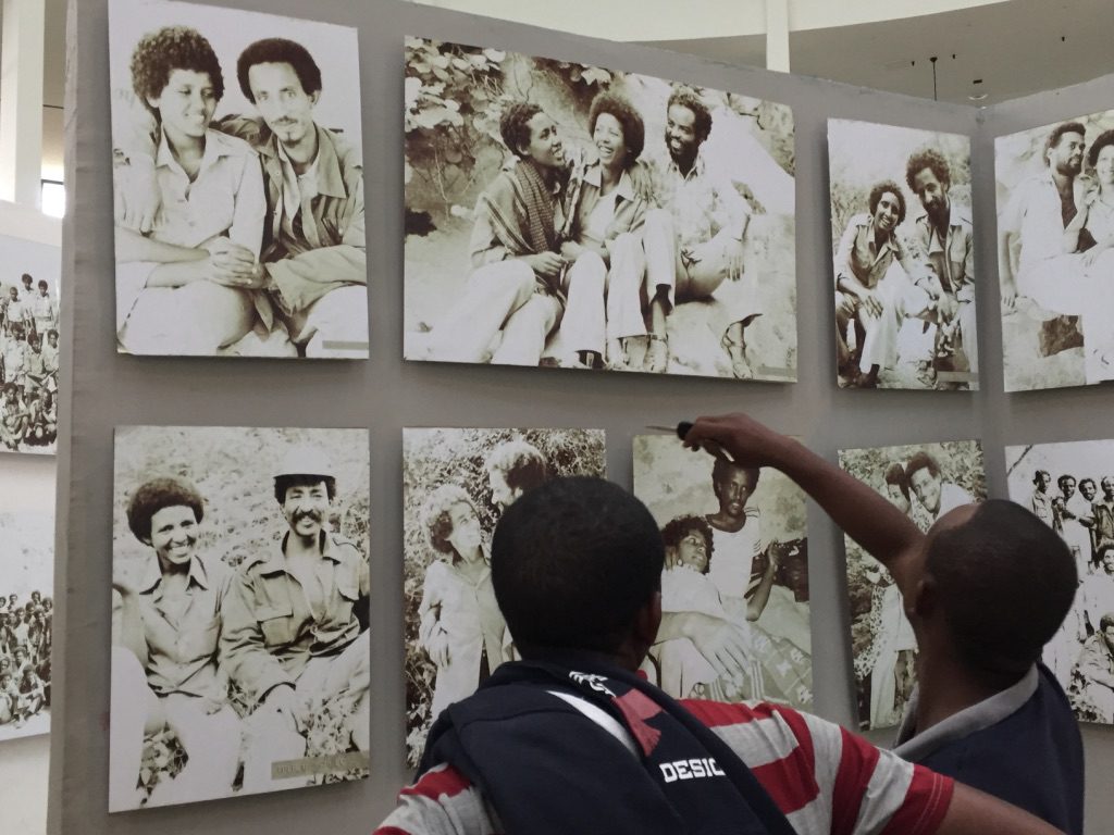 Two men visit the museum and point to a photo.