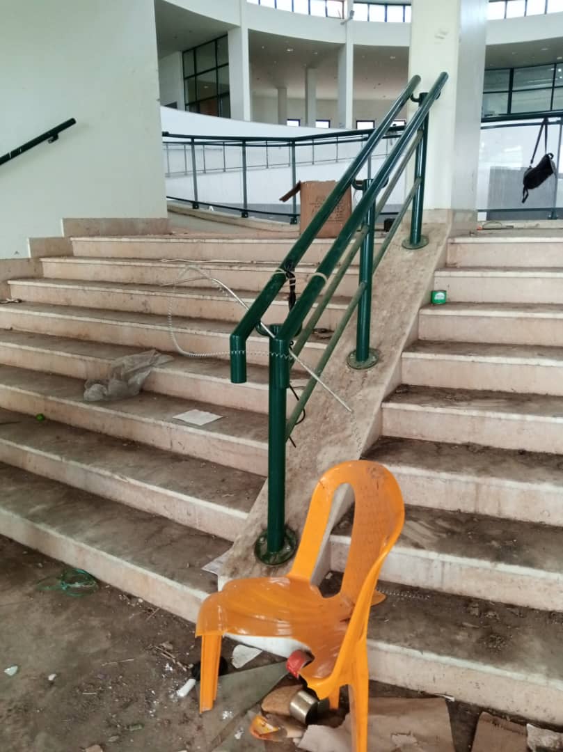 Yellow plastic chair near a banister, and electric cables, that appear to have been used to torture people held prisoner.