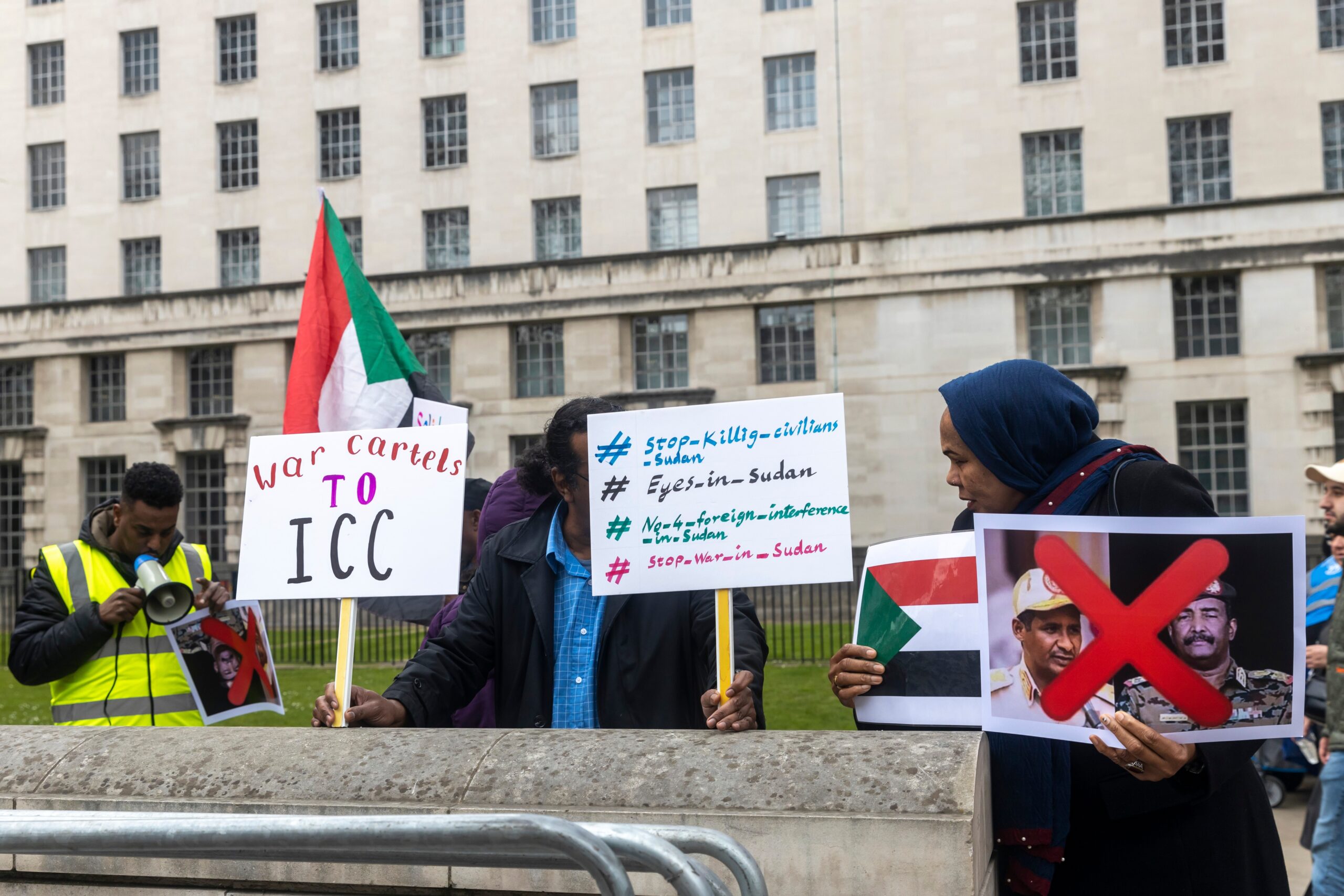 protesters holding signs to stop war in Sudan