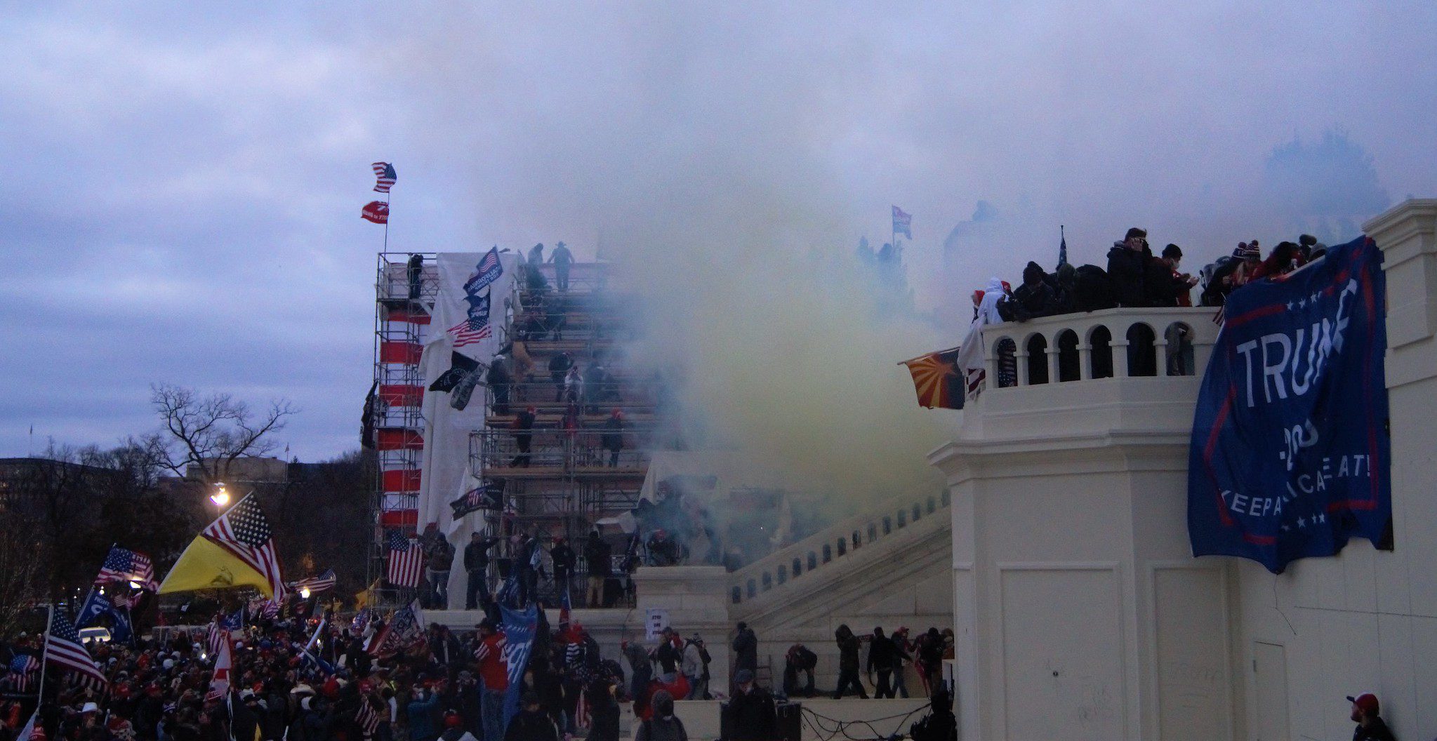 photo of Jan 6 capital riot, Washington DC, large mob of people with Trump flags and tear gas