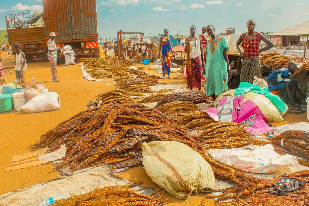 market scene in South Sudan, bags of grain and sudanese people at market