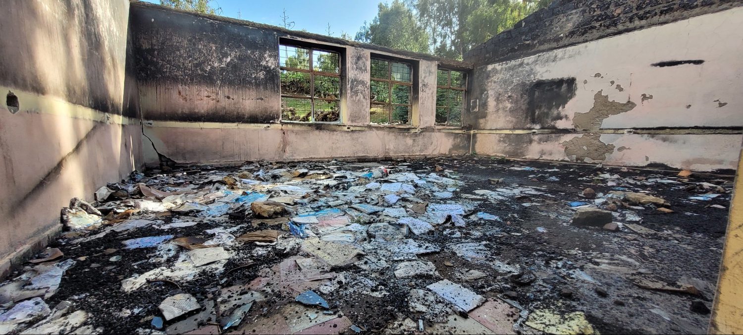 ruined text books covering the floor of a destroyed classroom in Ethiopia