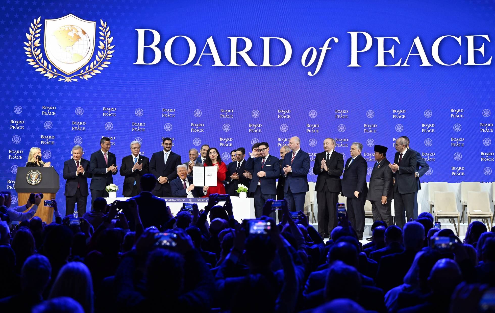 group of people on stage celebrating document signing