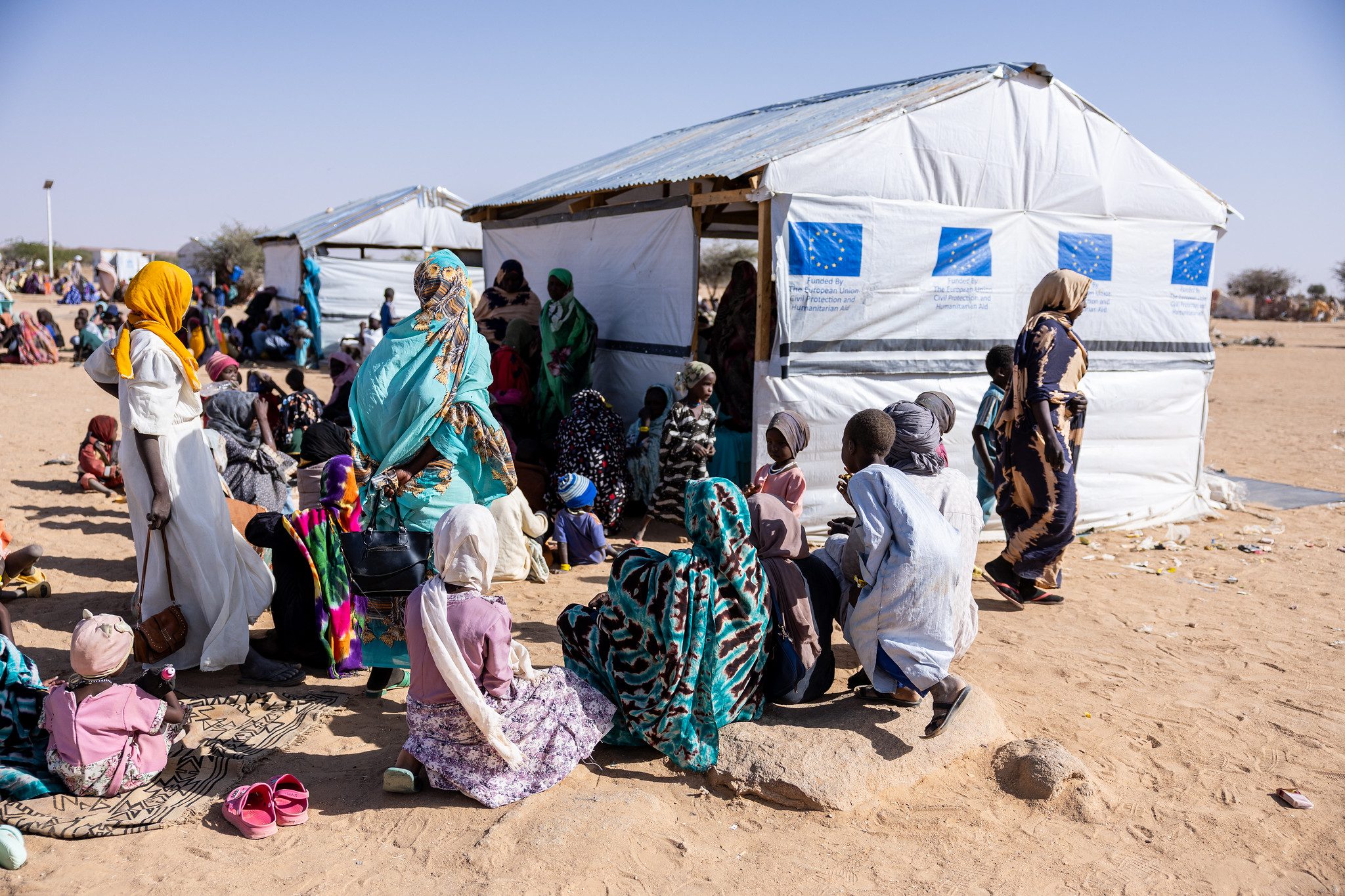 refugees from Darfur huddle around small structure