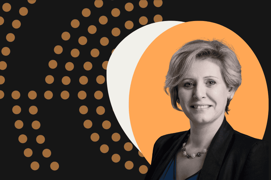 woman in black suit against orange, white and black decorative background